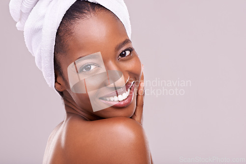 Image of Hair towel, portrait and happy black woman in studio for skincare, wellness or body care on purple background. Beauty, cleaning or hands on face of African female model with cosmetic, shine or glow