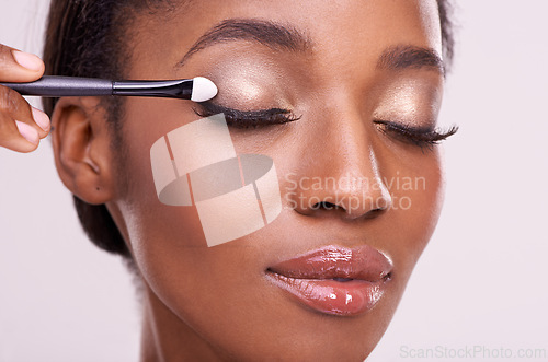 Image of Black woman, face and brush for eyeshadow with makeup, beauty and lashes isolated on pink background. Skin glow, cosmetics product and tools for cosmetology, shimmer or glitter with shine in studio