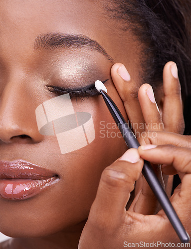 Image of Closeup of black woman, brush and eyeshadow with makeup, beauty and lashes with eyeliner. Skin glow, hands and cosmetic product application with tools for cosmetology, shimmer or glitter with shine