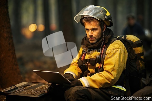 Image of Firefighter Using Laptop in a Smoky Forest