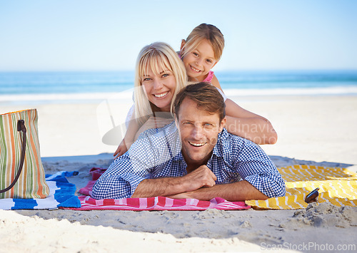 Image of Parents, girl and portrait on blanket at beach with care, love and bonding in summer to relax on holiday. Father, mother and daughter with picnic, connection and happy by sea in sunshine on vacation