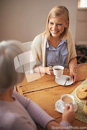 Image of Daughter, happy woman and senior mother drinking tea at breakfast, bonding and smile. Elderly mom, adult and coffee cup at table for conversation, food and family eating cookies at home together