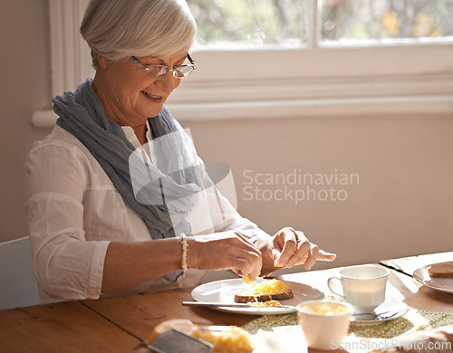 Image of Senior, woman and eating breakfast in home with bread, cheese and tea with happiness by table in the morning. Elderly, person and smile with lunch, snack or food for nutrition and meal in dining room