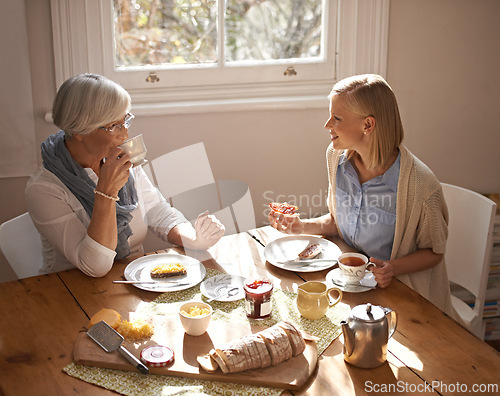 Image of Happy woman, senior mother and eating breakfast, drinking coffee and conversation at home together. Smile, elderly mom and daughter with tea cup at table, food and family with healthy cheese on bread