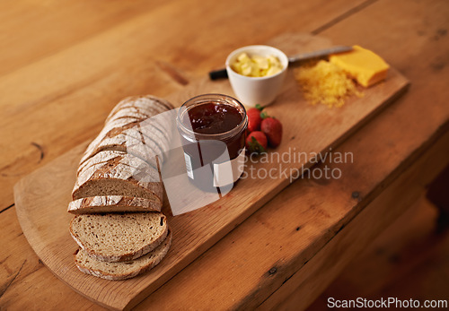 Image of Breakfast, charcuterie and cheese with jam, bread and fresh strawberry for diet, nutrition and gourmet morning snack. Food, fruit and high angle of sweet, savory and delicious rustic brunch on board.