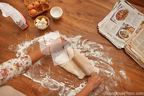 Image of Dough, recipe and hands with rolling pin on table, above baking in kitchen and closeup on process in bakery. Person, prepare and press bread with flour and meal prep with information guide in book