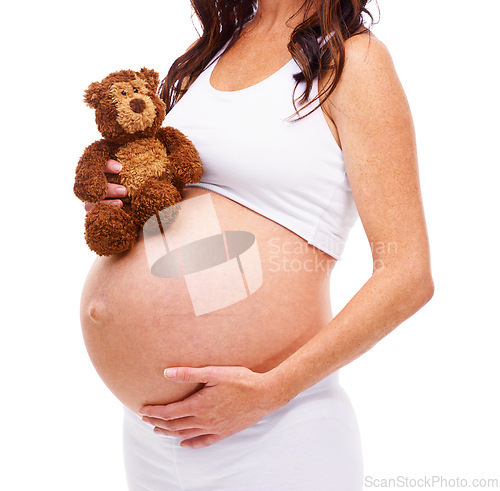 Image of Woman, pregnant and teddy bear in studio with hand on stomach for care, support or love for future child. Mother, belly and protection of baby with abdomen, wellness and maternity on white background