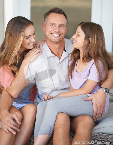 Image of Dad, girl and mom in portrait on patio with hug, care and love with dad with smile at family home. Father, mother and daughter with embrace, connection or happy to relax together in backyard at house