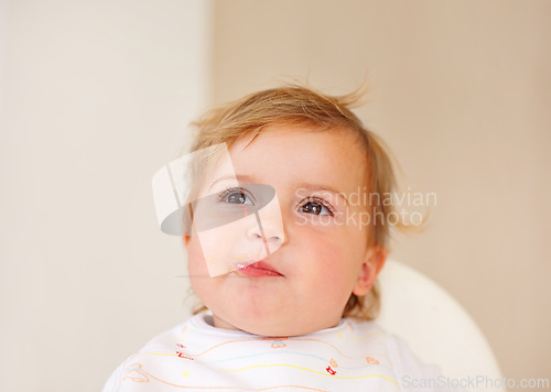 Image of Happy, baby and eating as thinking of food, tasty and messy for healthy, childhood and development. Smile, cute child and hungry for meal, delicous and nutrition for wellbeing, health and growth