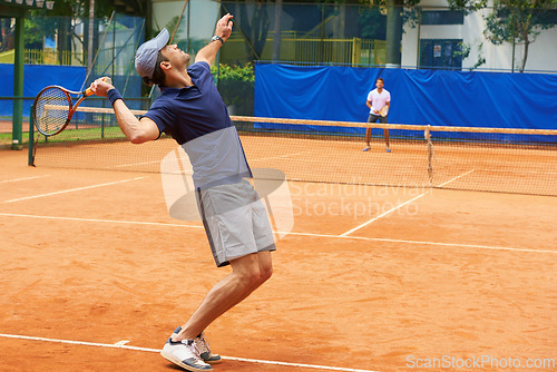 Image of Exercise, sports and tennis with man serving on clay court to start competition or game from back. Fitness, training or workout and athlete man with racket in stadium or venue at beginning of match