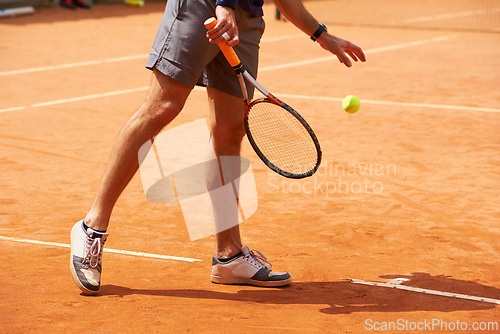 Image of Tennis, court and legs of person outdoor at start of exercise of workout in competition. Athlete, serving and sneakers of player training with ball on clay pitch in sport, game and action in fitness