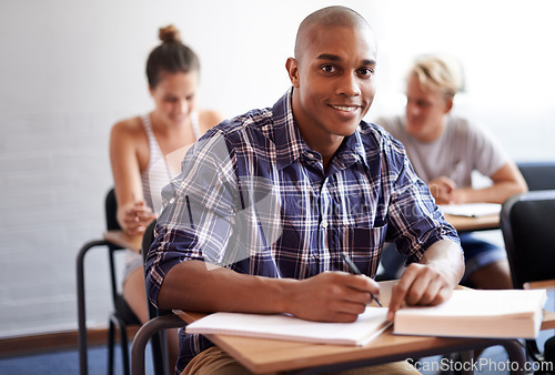 Image of Black man, portrait and student with book in classroom for studying, reading or writing summary at university. African male person or academic writer with smile for assignment, test or exam at campus