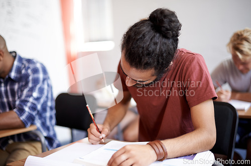 Image of Man, class and writing in college, learning and knowledge on campus for education. Student, male person and notes for information in book, planning and research for studying or revision for exams