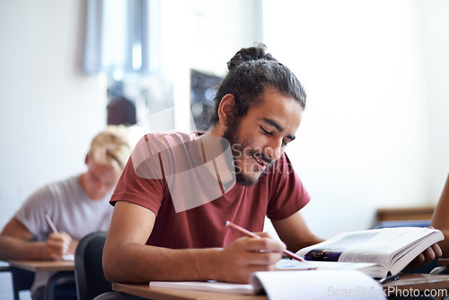 Image of College, student and man with smile for learning with textbook, scholarship and studying for education. Male person, happy and reading for information with research on table or desk of classroom