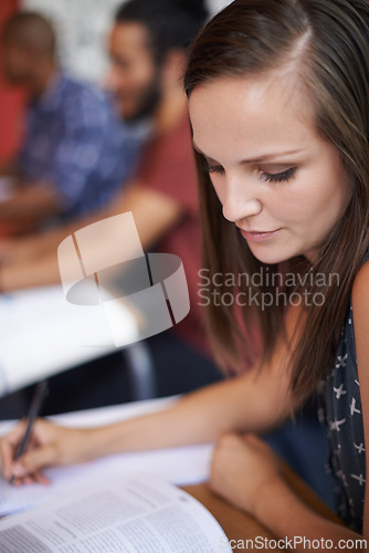 Image of Woman, student and writing with textbook in classroom for notes, summary or studying at university. Female person or academic writer reading book for literature, test or knowledge on table at campus