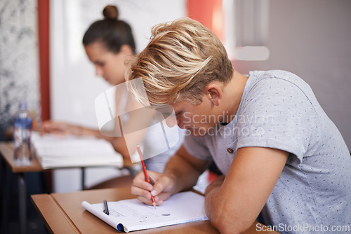 Image of Man, student and writing with book in classroom for studying, reading or summary at university. Male person or academic writer taking notes for assignment, test or literature exam on desk at campus