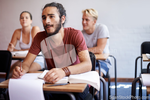 Image of Man, students and classroom with thinking, writing and listening to lecture with education, notes and ideas at desk. Person, learning and assessment with books, pen or attention to study at college