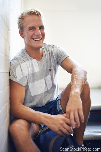 Image of Portrait, stairs and university with student, man and smile with lunch break and education. Face, person and guy sitting on stairwell, relaxing and college with knowledge and happy with scholarship