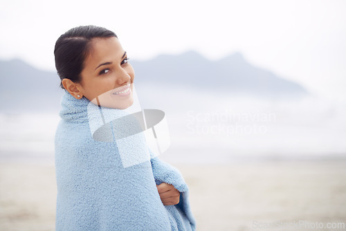 Image of Woman, towel and beach with portrait, smile and sand for relax and rest in cape town. Tourist, ocean and sea for travel, adventure and holiday with blanket for comfort and positivity in nature