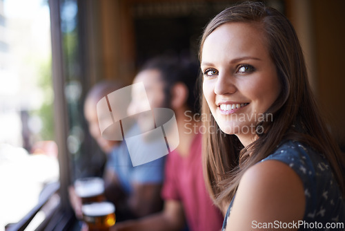 Image of Portrait, happy and a woman at pub to relax, cheerful or positive facial expression for leisure at restaurant tavern. Face, bar and smile of young female person or casual customer at cafe for alcohol