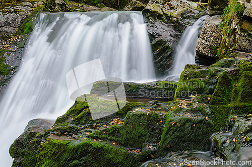 Image of Cascading waterfall surrounded by lush greenery in a forested la