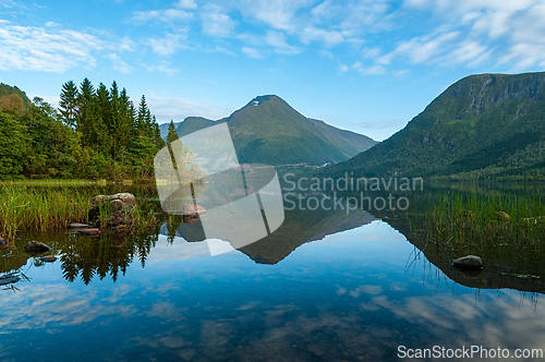 Image of Serene lake at dawn with reflection of surrounding mountain and 