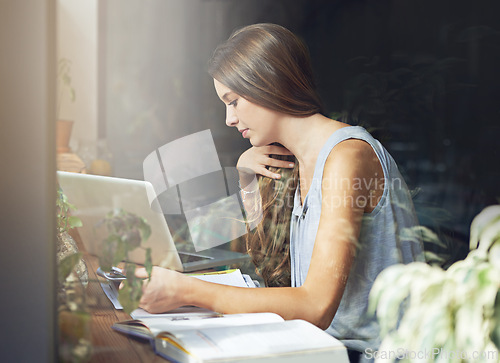 Image of Student, woman and reading in cafe for education, knowledge and study with notebook, laptop or scholarship. Young girl, learning or research in books for assignment, assessment or exam in coffee shop