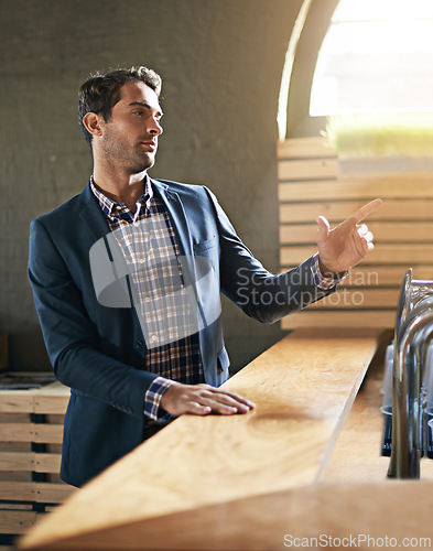 Image of Businessman, table and order drink in bar after long day at work, relax and pub counter for wine. Male person, buying and beer for leisure after job for happy hour, call and hand sign for waiter