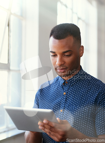Image of Businessman, tablet and reading at window for communication, internet search or networking in office. Entrepreneur, african employee or serious with technology for startup email or planning at work