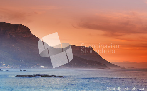 Image of Ocean, sunset and mountains in nature or sustainable environment and travel destination for vacation. Landscape, sea or sunlight on water on beach, calm or seascape of camps bay for tourist adventure