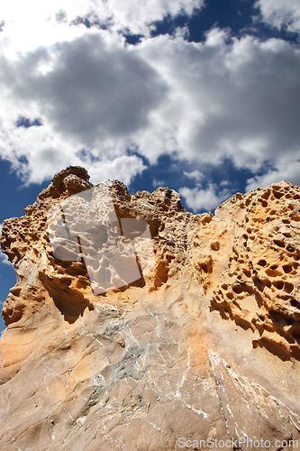 Image of Mountain, rocks and natural landscape with cloudy sky, summer and sunshine on peak at travel location. Nature, cliff and sustainable environment with earth, stone and tropical holiday in low angle