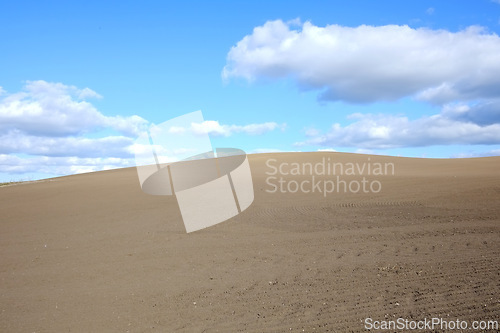 Image of Desert, landscape and clouds on blue sky background with sand in arid, barren or dry environment. Earth, nature or soil and summer horizon in hot climate or drought with banner, mockup or space