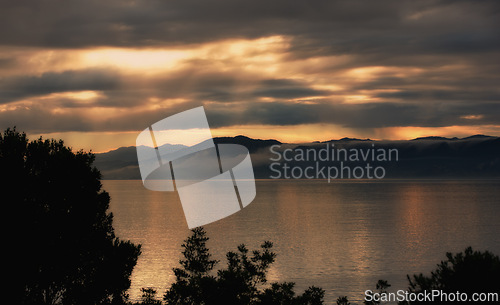 Image of Landscape, silhouette and ocean on sunset background for environment, weather and travel or adventure. View of empty sea or water in nature with clouds, winter and sunset in Wellington, New Zealand