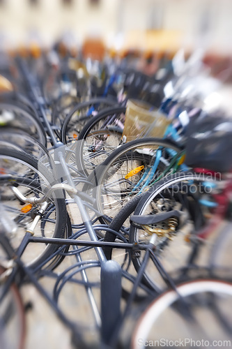 Image of Bike rack, blur and travel in city, eco friendly and carbon footprint with closeup of transportation outdoor. Bicycle park, cycling and background for sustainable journey, environment and commute