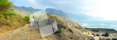 Image of Trail, landscape and sky with ocean in nature for travel, adventure or hiking with mountain view in Hawaii. Pathway, gravel road or location with rocks, roadway or environment for holiday or vacation