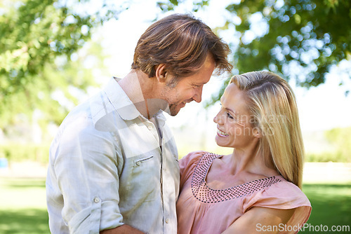 Image of Couple, happy and hug in nature with love on honeymoon date, bonding or anniversary vacation with embrace. Face, man and woman with smile outdoor at park for relax, healthy relationship or summer fun