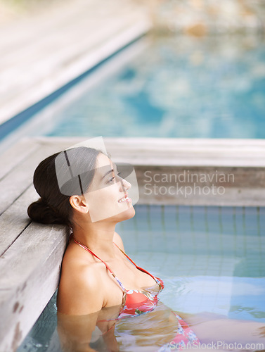 Image of Woman, happiness and relax in jacuzzi at spa with thinking, vacation or holiday fun in summer with bikini. Tourist, person and face with smile in pool for swimming, hydrotherapy and wellness at hotel