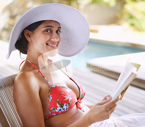Image of Woman, relax and outdoor with book by poolside for reading on holiday or getaway on weekend in summer. Happy and tanned person with smile and novel bikini for swim and vacation for travel and rest