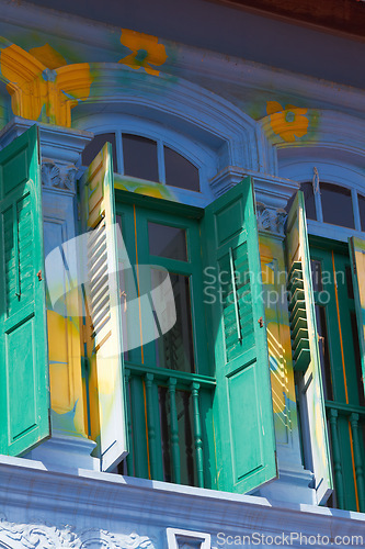 Image of Colorful, window and paint with home exterior, balcony design or building of wall, texture or creativity on wooden doors. Glass, flower pattern and art on shutters, feature or outdoor house decor