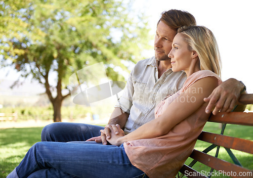 Image of Couple, happiness and bench in park with love on honeymoon date, bonding and anniversary vacation. Holding hands, man and woman with smile outdoor for relax, healthy relationship and summer holiday