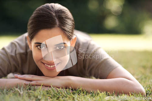 Image of Portrait, Indian woman and lying on grass with smile at park for joy, refresh and relax with me time. Female person, bokeh and happy for leisure with break for rest, peace and quiet with wellbeing