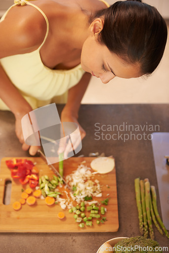 Image of Cooking, food and health with chef in kitchen of home to prepare meal for diet or nutrition from above. Woman, nutritionist or vegan and person cutting green vegetables with knife in apartment