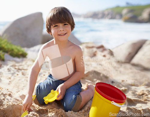 Image of Sand castle, beach and portrait of child with bucket and toys on summer holiday, vacation and relax by ocean. Childhood, building sandcastle and young boy playing for adventure, fun or weekend by sea
