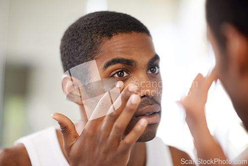 Image of Face, skincare and lotion with black man in bathroom mirror of home to apply antiaging treatment. Beauty, cream and cosmetics with reflection of young person in apartment for skin moisturizer