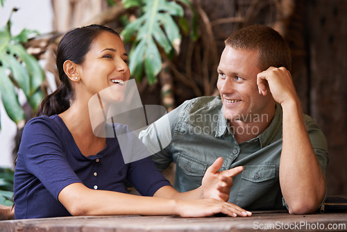 Image of Love, happy and couple at a cafe for date, bonding and fun gossip, catch up and conversation. Care, romance and people relax at a coffee shop with support, trust and chat, security and listening