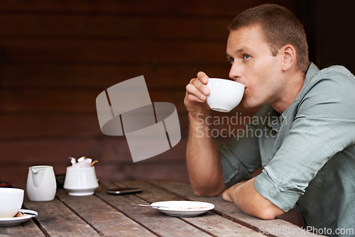 Image of Thinking, idea and man at a cafe for coffee break, chilling or morning caffeine routine. Restaurant, tea cup and male person with moment of reflection, memory or calm contemplation while drinking