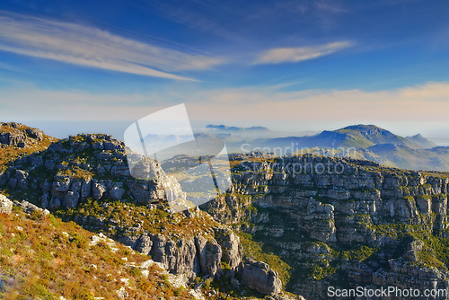 Image of Mountains, blue sky and natural landscape with clouds, cliff and calm location for travel destination. Nature, fog and sustainable environment with earth, peace and holiday with sunset on horizon.