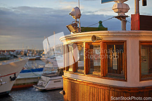 Image of Boat, water and harbor at sea to travel with closeup, windows and transportation for vacation sailing. Ship, dock and ocean with yacht for tourism, holiday and adventure with sunset, sky and nature