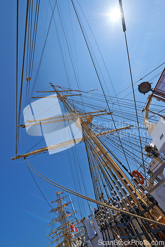 Image of Sailing, boat and mast outdoor with flag for travel, journey and low angle of blue sky in summer. Ship, wood pole and vintage schooner vessel on a cruise, rigging and transport in nature with rope