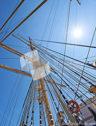 Image of Sailing, ship and mast outdoor with rope for travel, journey and low angle of blue sky in summer. Boat, wood pole and vintage schooner vessel on a cruise, rigging and transportation with sunshine